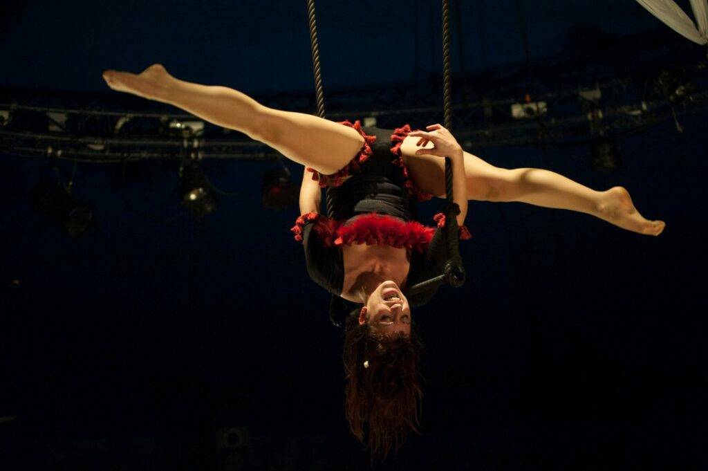 Una donna appesa a testa in giù ad un trapezio